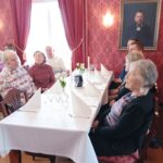 Ihmisiä ruokapöydän äärellä