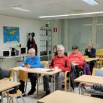 Ihmisiä istumassa pöytine takana.